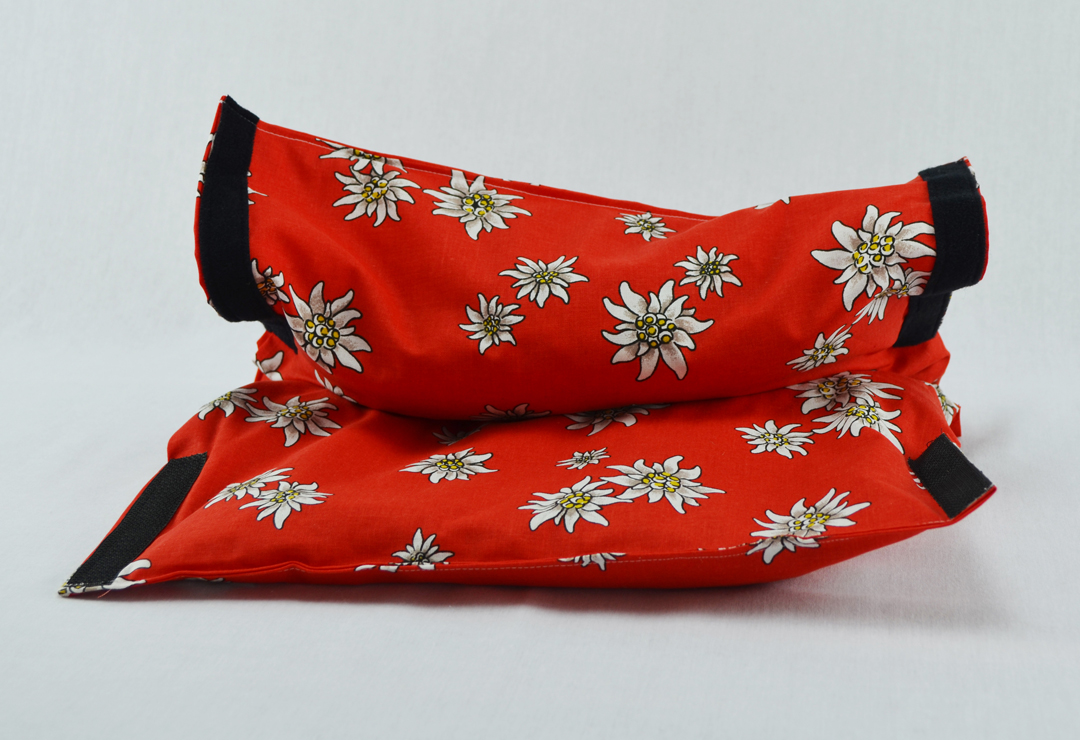 Le « Chriesisteisäckli » original, chauffe-pieds en rouge avec motif d'edelweiss et fermeture velcro